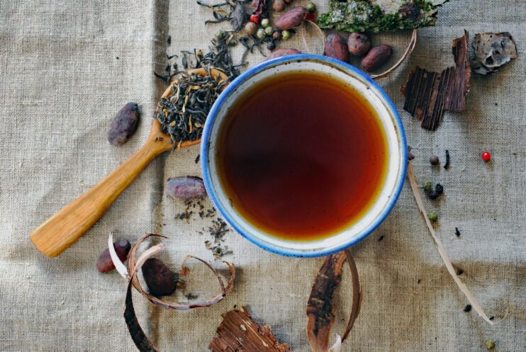 picture of cup of tea with herbs spread around